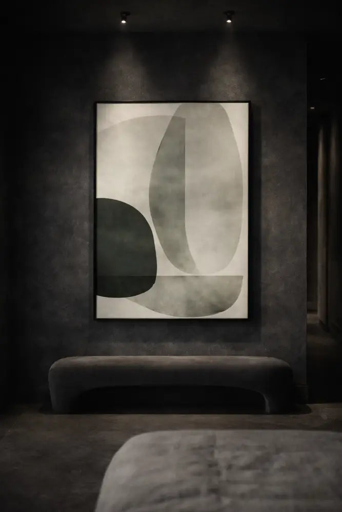 Une peinture abstraite moderne avec des formes en gris doux et en vert atténué sur une toile blanche, encadrée dans un cadre noir élégant.