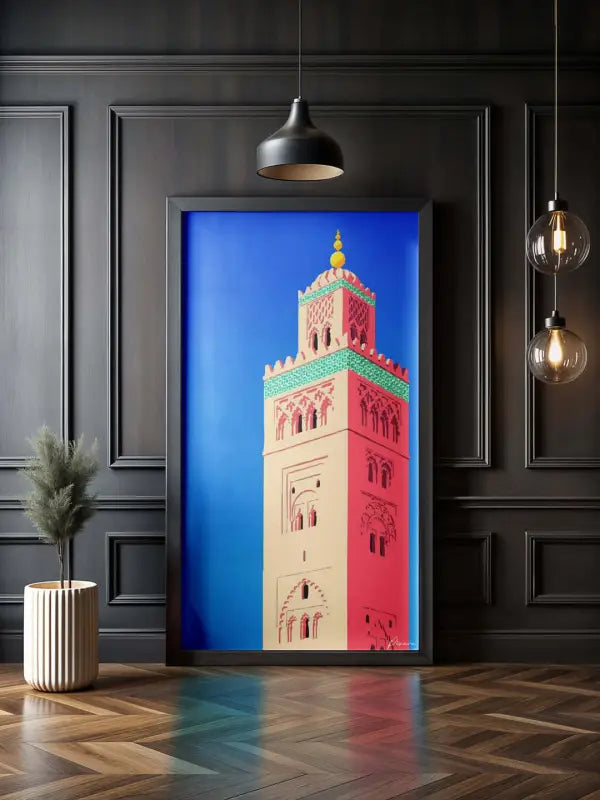 Une œuvre d’art encadrée vibrante représentant un minaret avec des détails architecturaux en rose, crème et vert sur un fond bleu audacieux.