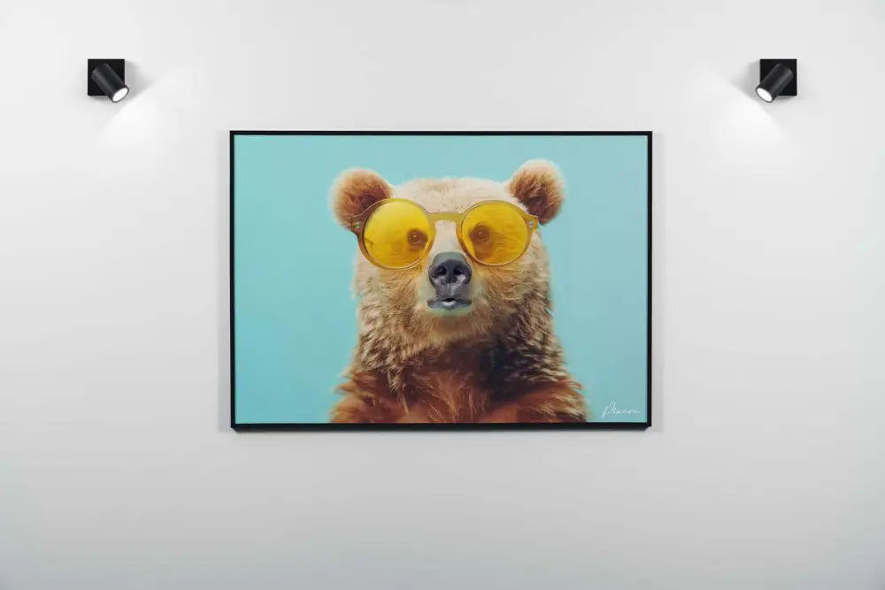 Une impression sur toile encadrée représentant un ours brun portant des lunettes de soleil jaunes élégantes sur un fond uni bleu clair.