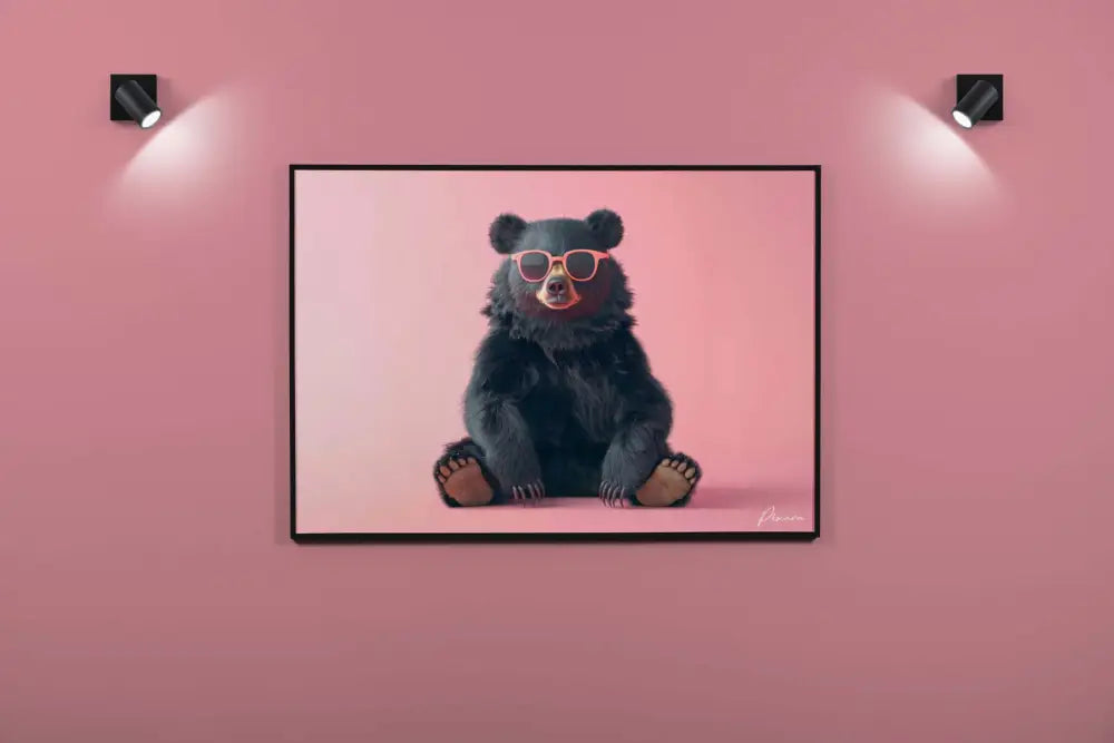 Une œuvre d’art encadrée représentant un ours noir portant des lunettes élégantes à monture orange, sur un fond rose doux.