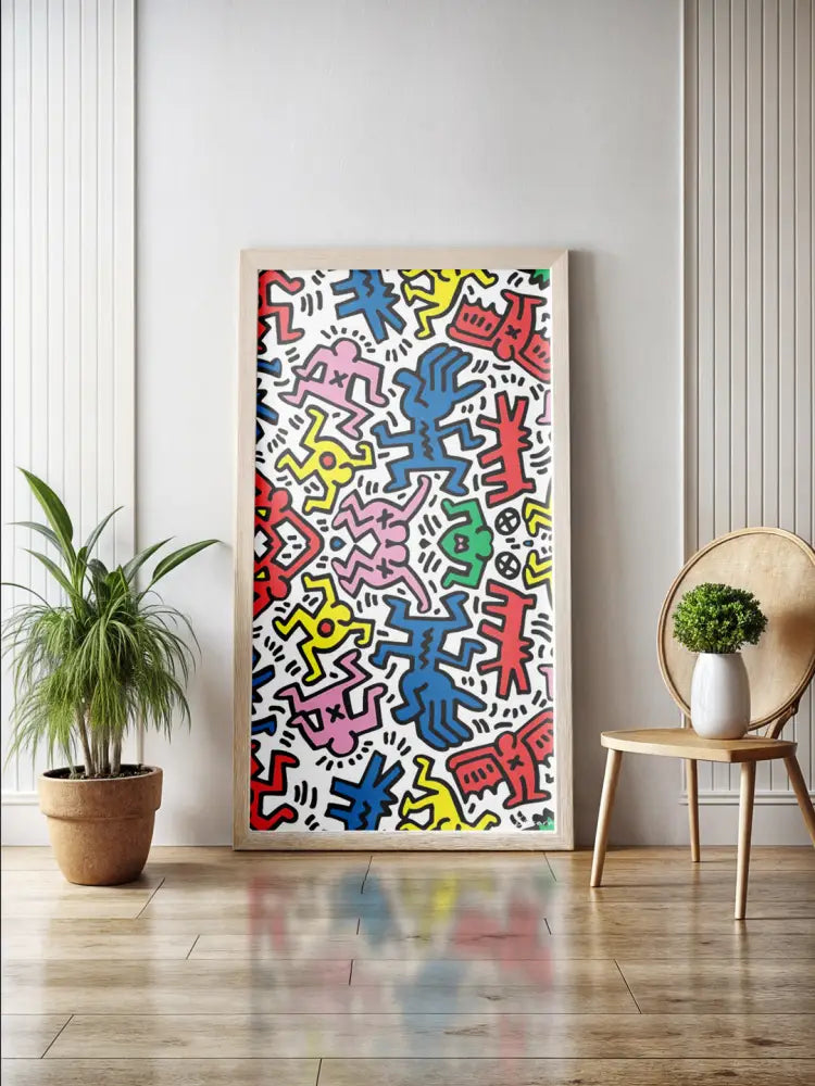 Une œuvre d’art encadrée vibrante mettant en scène des figures stylisées colorées en rouge, bleu, jaune et rose sur un fond blanc.