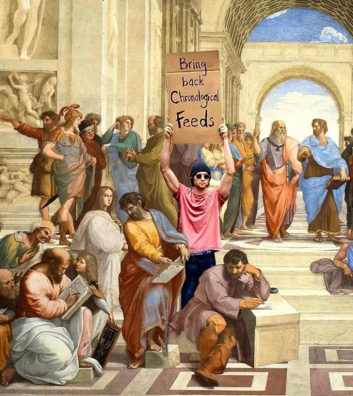 Un homme en t-shirt rose et bonnet bleu bleu tient une pancarte en carton sur laquelle on peut lire « ramenez les flux chronologiques ».