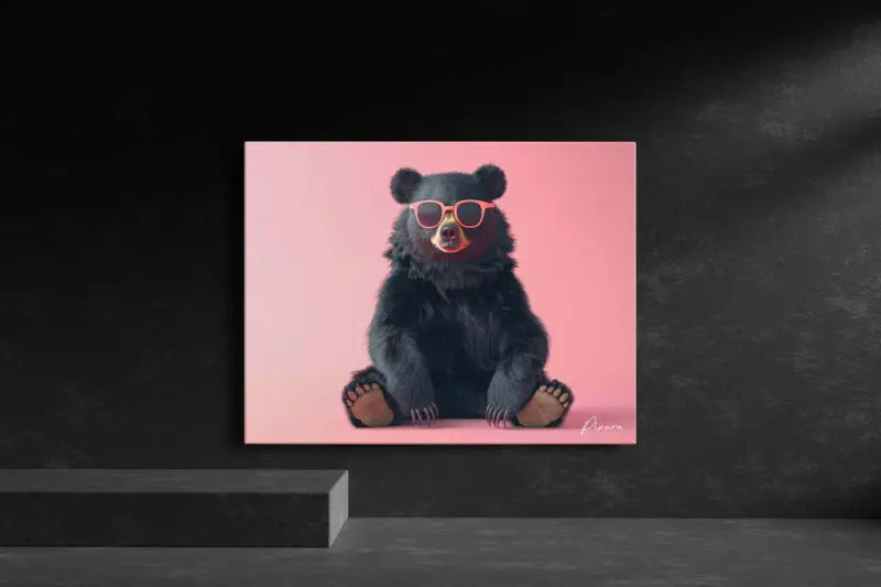 Un ours noir portant des lunettes de soleil roses est assis sur une toile rose vibrante.