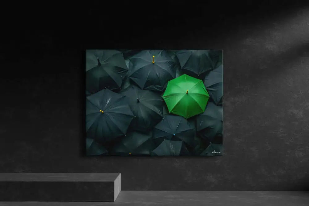 Un parapluie vert vibrant se distingue au milieu d’une mer de parapluies sombres et fermés dans cette œuvre d’art mural minimaliste.