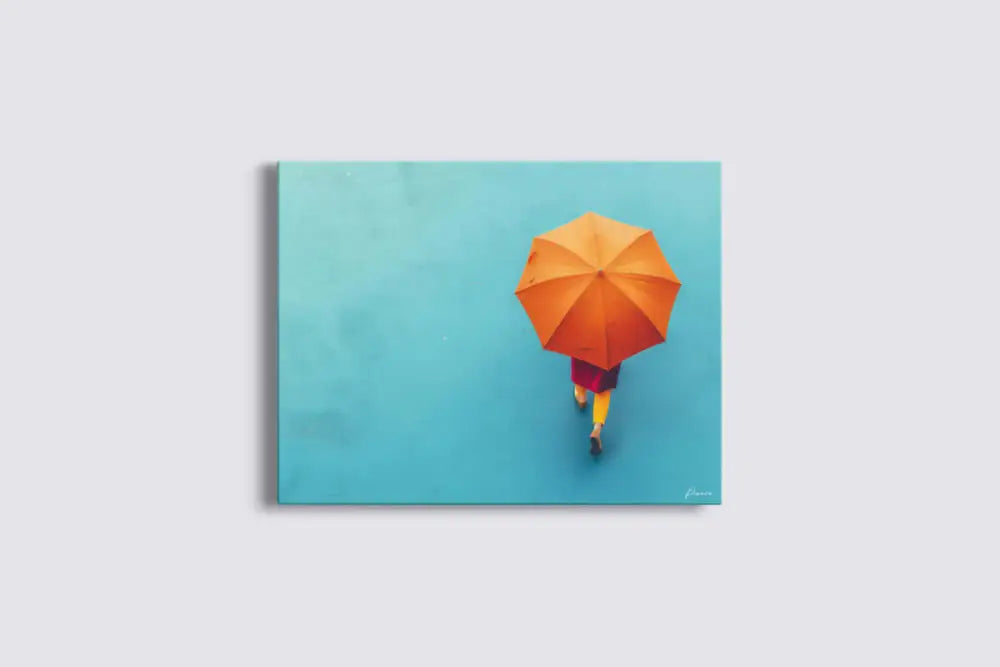 Parapluie orange vibrant tenu par une silhouette s’éloignant sur un fond uni turquoise.