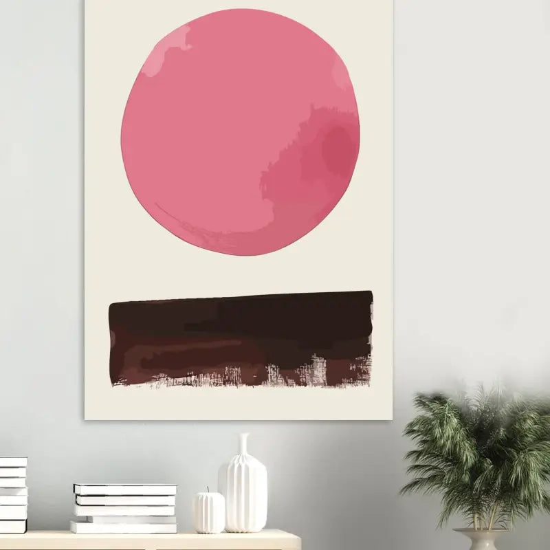 Une impression sur toile minimaliste mettant en scène une forme circulaire rose audacieuse au-dessus d’une silhouette abstraite de ville dans un brun foncé.