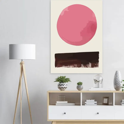 Une toile abstraite minimaliste présentant une forme circulaire rose audacieuse au-dessus d’une bande horizontale texturée marron foncé sur un fond blanc cassé.