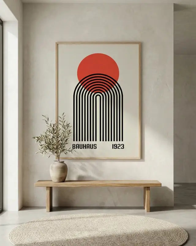 Une affiche minimaliste inspirée du Bauhaus dans un cadre en bois clair, présentant des lignes courbes noires audacieuses et un soleil circulaire orange sur un fond crème.