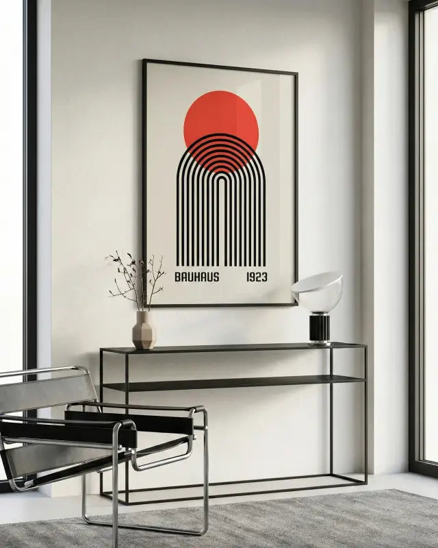 Une affiche encadrée minimaliste présentant un soleil circulaire rouge audacieux au-dessus d’arches concentriques noires, avec le texte « bauhaus 1923 » imprimé en dessous dans une police sans-serif propre.