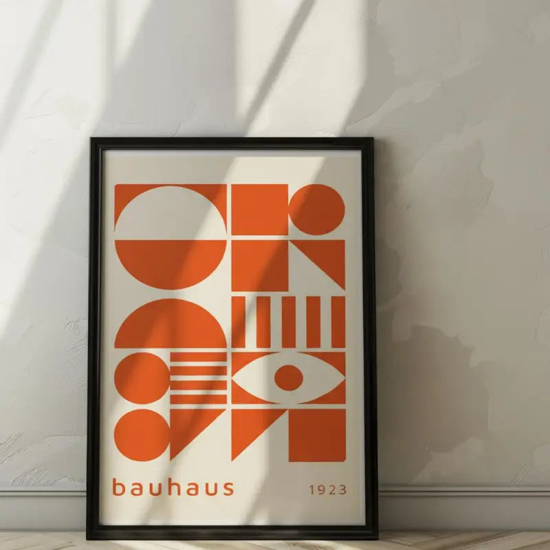 Une affiche encadrée de style Bauhaus avec des formes géométriques orange audacieuses sur un fond crème, enchâssée dans un cadre noir élégant.