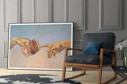 Une impression d’art encadrée dépeignant une parodie de ’la création d’Adam’ avec deux mains se tendant l’une vers l’autre, l’une tenant un pot ouvert de Nutella.