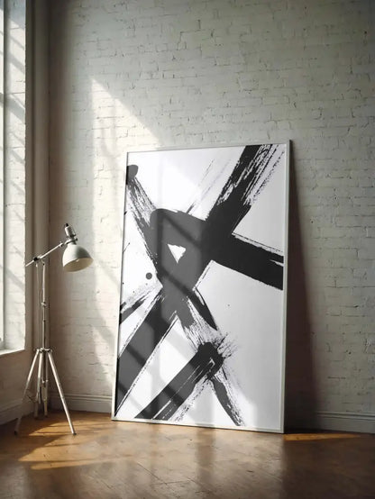 Une peinture abstraite moderne avec des coups de pinceau noirs audacieux sur une toile blanche, encadrée dans un cadre argenté élégant.