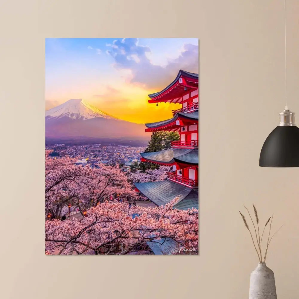 Pagode rouge vibrante aux toits en tuiles gris foncé se dresse au milieu de cerisiers en fleurs roses, sur fond du mont Fuji enneigé au coucher du soleil.