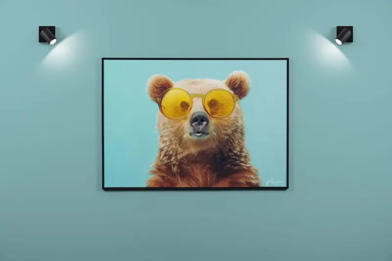 Une impression sur toile encadrée présentant un ours brun portant des lunettes de soleil jaunes surdimensionnées sur un fond bleu clair.