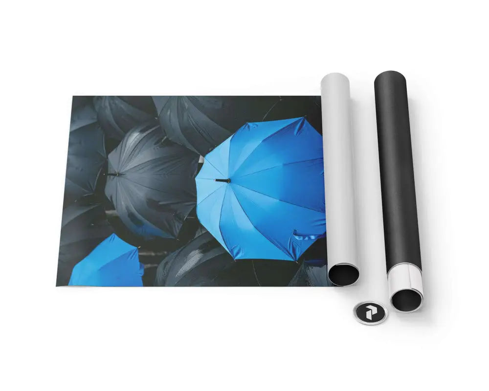 Un parapluie bleu vibrant se distingue sur un fond d’ombrelles gris foncé dans cette œuvre d’art murale imprimée, présentée avec son emballage roulable.