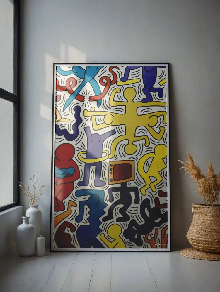 Une œuvre d’art vibrante, encadrée, dans le style de Keith Haring, présentant des figures abstraites audacieuses et colorées en rouge, bleu, jaune et violet sur un fond blanc.