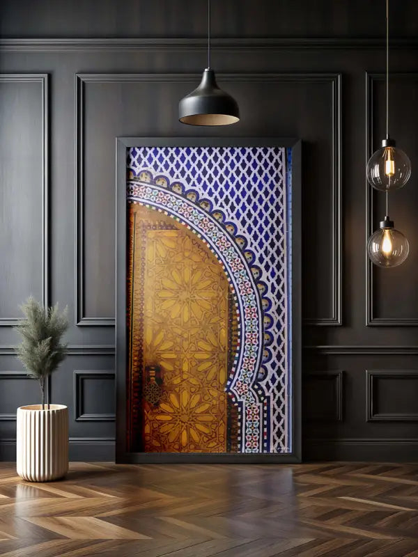 Une œuvre d’art encadrée représentant une porte arquée ornée de motifs de mosaïque dorés et bleus complexes.