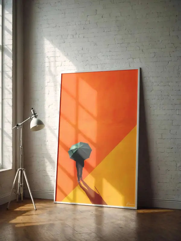 Une œuvre d’art encadrée présentant une silhouette minimaliste d’une personne tenant un parapluie sur un fond dégradé vibrant passant de l’orange au jaune.