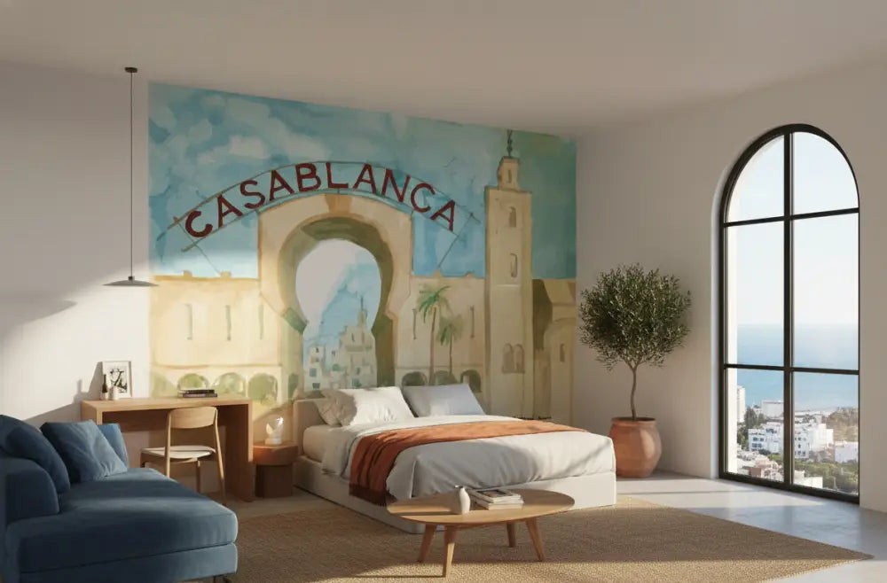 Le lit présente un matelas blanc avec une literie gris clair amidonnée et est rehaussé par une couverture orange drapée au centre.