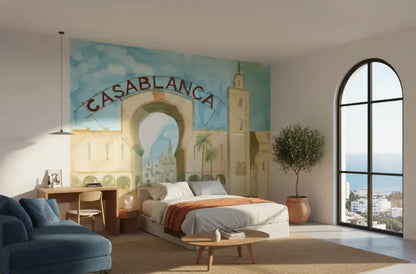 Le lit présente un matelas blanc avec une literie gris clair amidonnée et est rehaussé par une couverture orange drapée au centre.