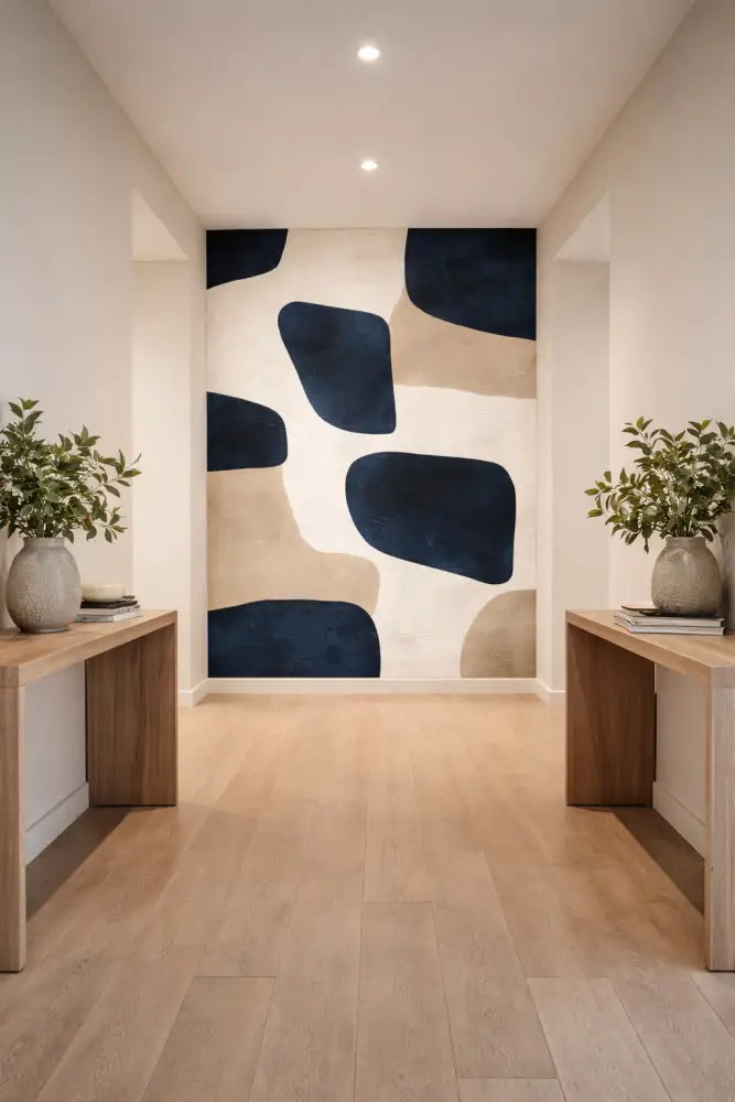 Une frise murale abstraite moderne mettant en scène des formes organiques audacieuses en bleu marine et beige sur un fond blanc.