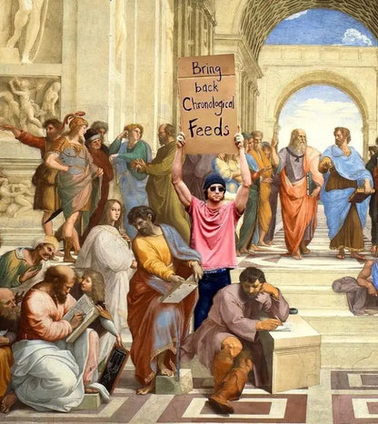 Un homme en t-shirt rose et bonnet bleu bleu tient une pancarte en carton sur laquelle on peut lire « ramenez les flux chronologiques ».