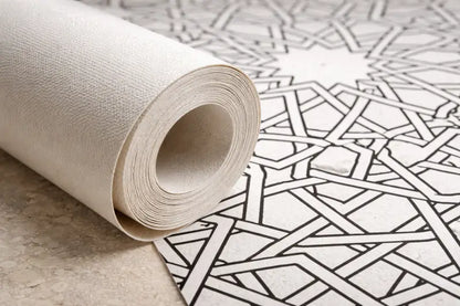 Un rouleau de papier peint texturé blanc cassé avec un motif de lignes géométriques noires.