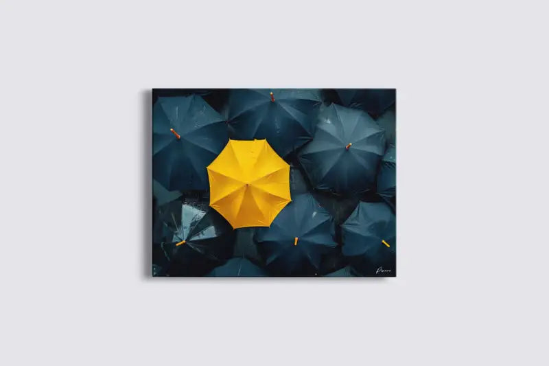 Un parapluie jaune vibrant se distingue sur un fond de parapluies bleu foncé dans cette œuvre d’art encadrée.