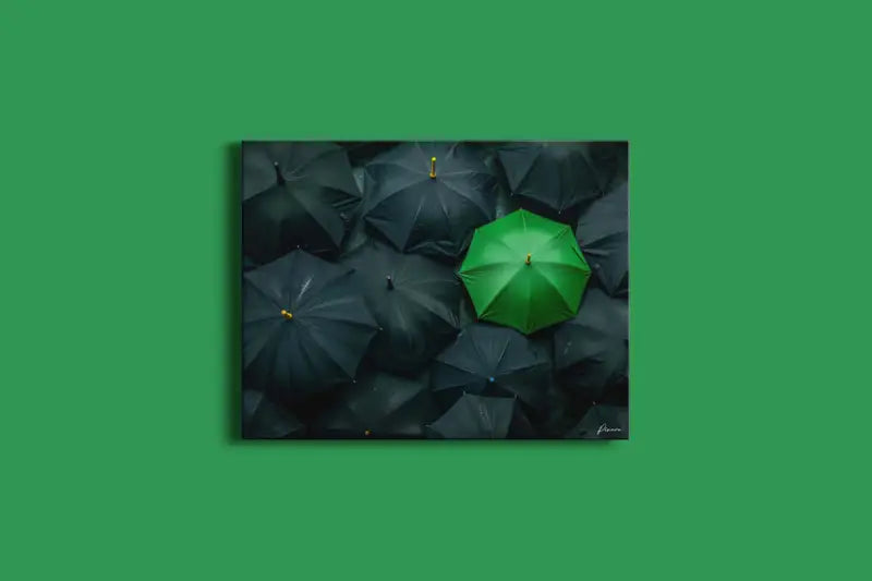 Un parapluie vert vibrant se distingue au milieu d’une mer de parapluies sombres dans cette œuvre encadrée.