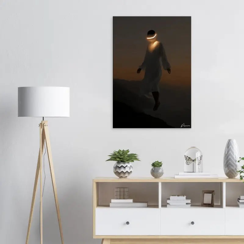 Une impression sur toile minimaliste représentant une silhouette contre un ciel dégradé orange et noir, avec des bandes lumineuses autour de la tête.