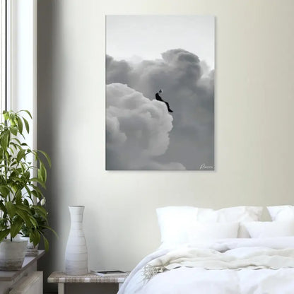 Impression sur toile noir et blanc représentant une figure solitaire assise au sommet de nuages volumineux.