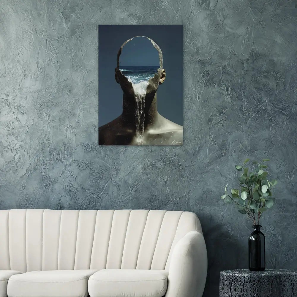 Une impression sur toile surréaliste représentant une figure humaine avec des vagues océaniques s’écoulant de sa tête, montée sur un mur gris texturé.