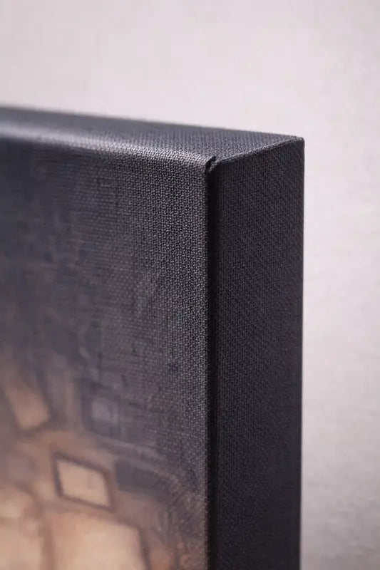 Impression sur toile noire avec un bord en tissu texturé tissé et un design géométrique abstrait en tons terre atténués.