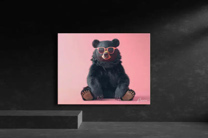 Un ours noir portant des lunettes de soleil roses est assis sur une toile rose vibrante.