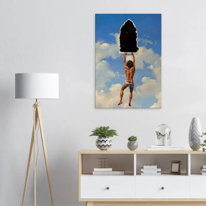 Une impression sur toile rectangulaire représentant un homme musclé en short gris soulevant un gros rocher noir sur un fond de ciel bleu avec des nuages blancs.