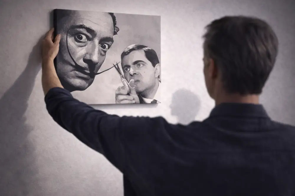 Une impression sur toile noir et blanc présentant un portrait surréaliste de Salvador Dalí avec sa moustache emblématique et un reflet illusoire de Rowan Atkinson dans le rôle du personnage de « L’Homme qui tua le bébé d’Hitler » tenant des ciseaux.