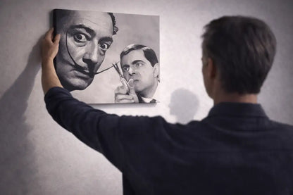 Une impression sur toile noir et blanc présentant un portrait surréaliste de Salvador Dalí avec sa moustache emblématique et un reflet illusoire de Rowan Atkinson dans le rôle du personnage de « L’Homme qui tua le bébé d’Hitler » tenant des ciseaux.