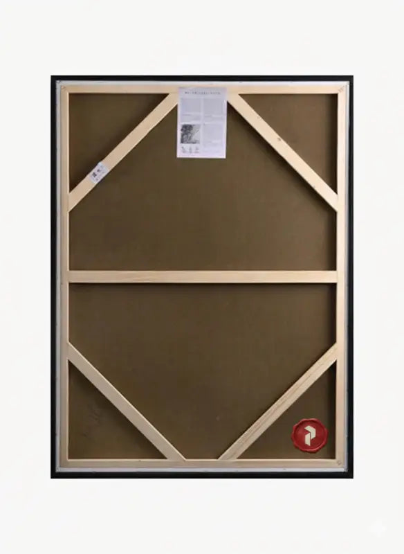 Le dos d’une peinture sur toile encadrée avec des châssis en bois clair et un cadre noir.