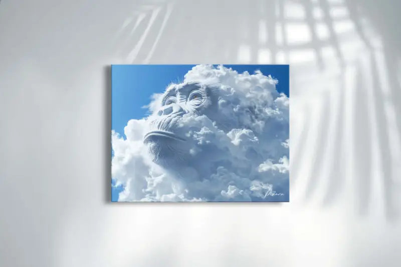 Un tirage sur toile rectangulaire mettant en vedette un visage de singe en pierre blanche frappant émergeant de nuages volumineux et duveteux sur un ciel bleu vibrant.