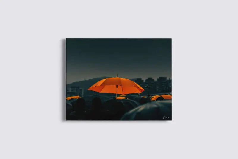 Un parapluie orange vibrant se détache sur un paysage urbain sombre et mélancolique dans cette impressionnante impression sur toile.