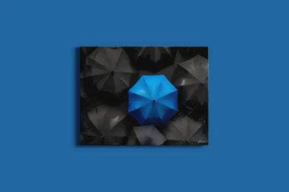 Un parapluie bleu vibrant se distingue sur un fond d’ombrelles sombres et ombragées dans cette impressionnante impression sur toile.