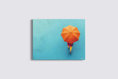 Parapluie orange vibrant tenu par une silhouette s’éloignant sur un fond uni turquoise.
